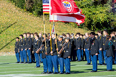 Military students holding up flags. Gifts by Beneficiary Designation